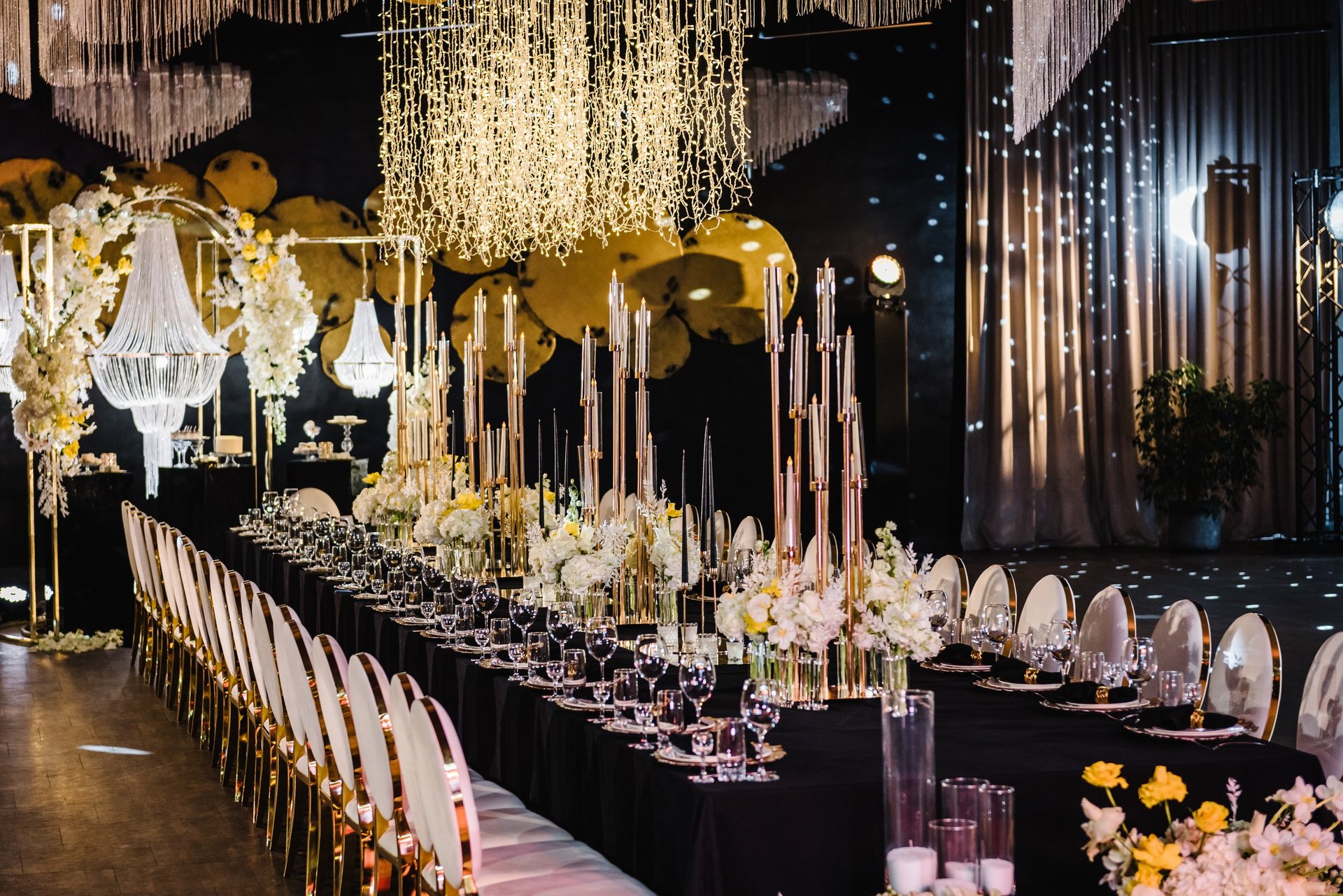 Banquet decoration in hall restaurant with festive tables and flower composition on black tablecloth