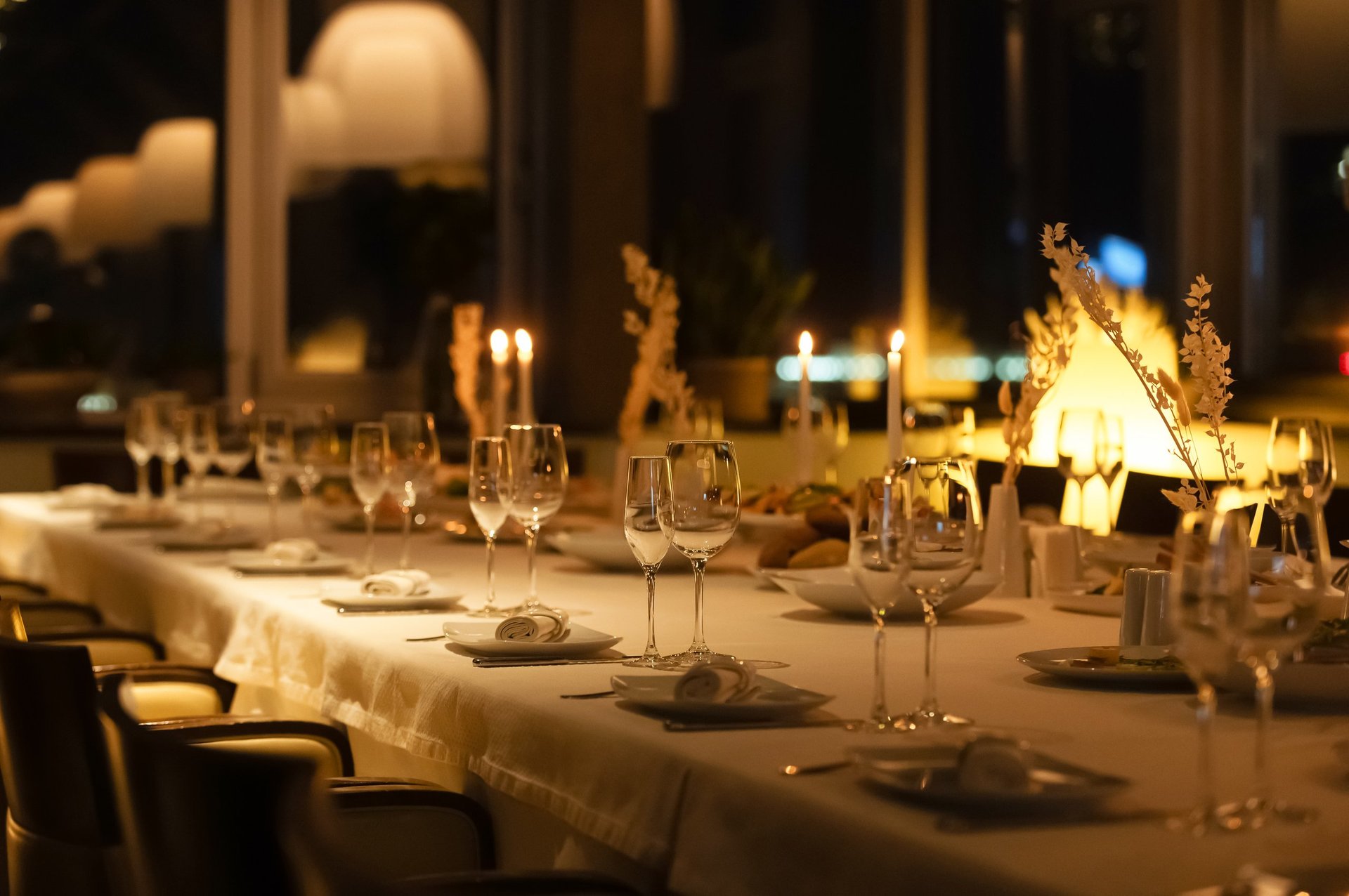 A beautifully arranged dining table set with glasses and candles, creating a warm atmosphere for guests