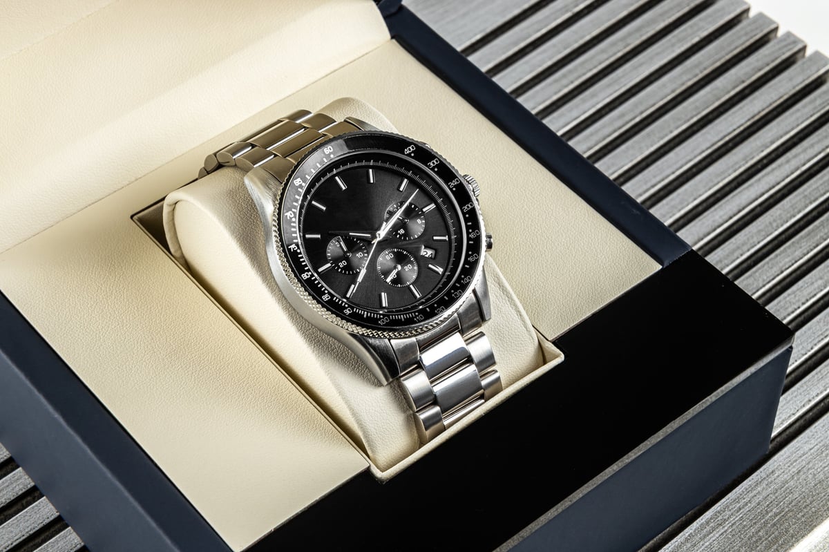 Modern men's wristwatch with black dial, gray stainless steel bracelet and elegant timeless design