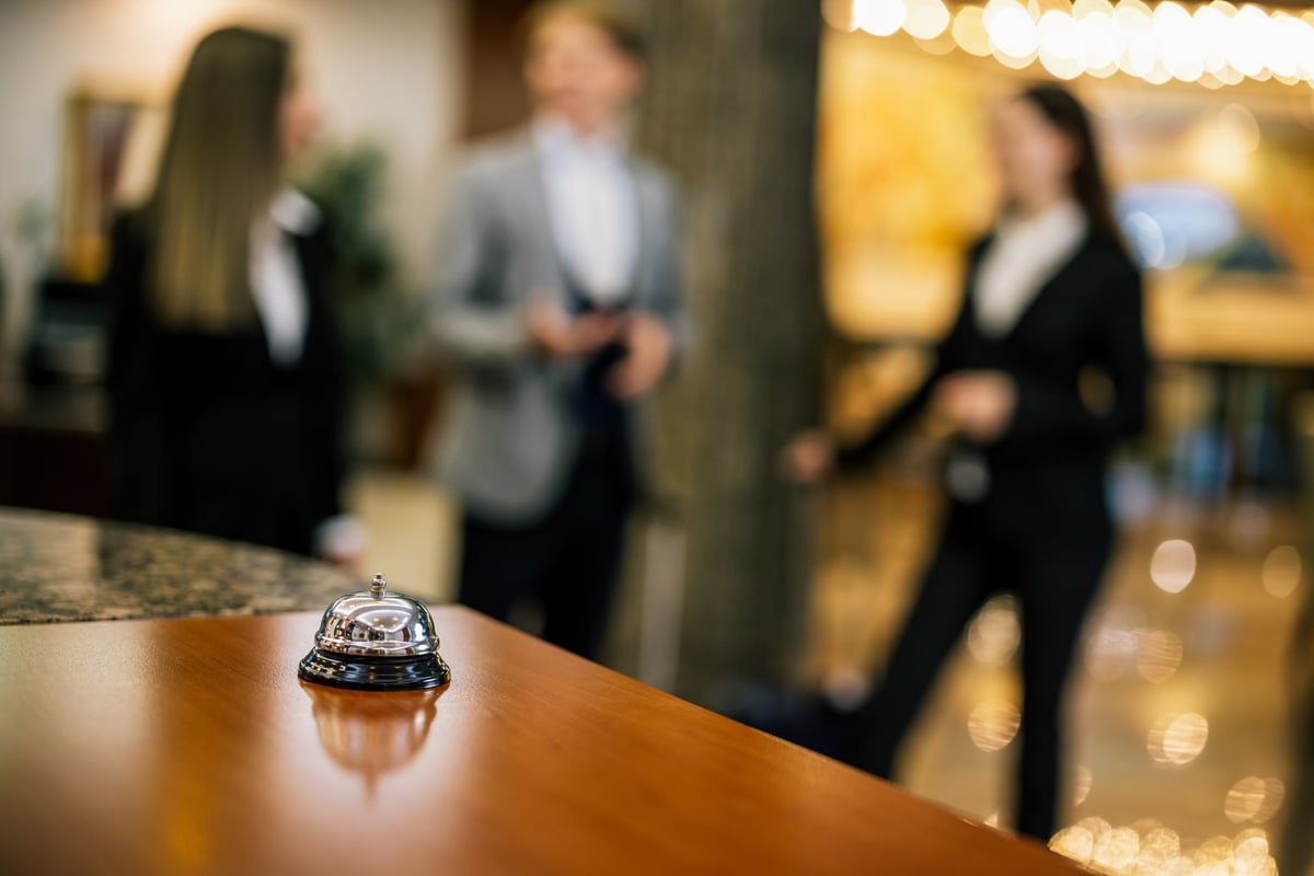 Macro shot of a brass concierge bell on the front desk of a luxury hotel